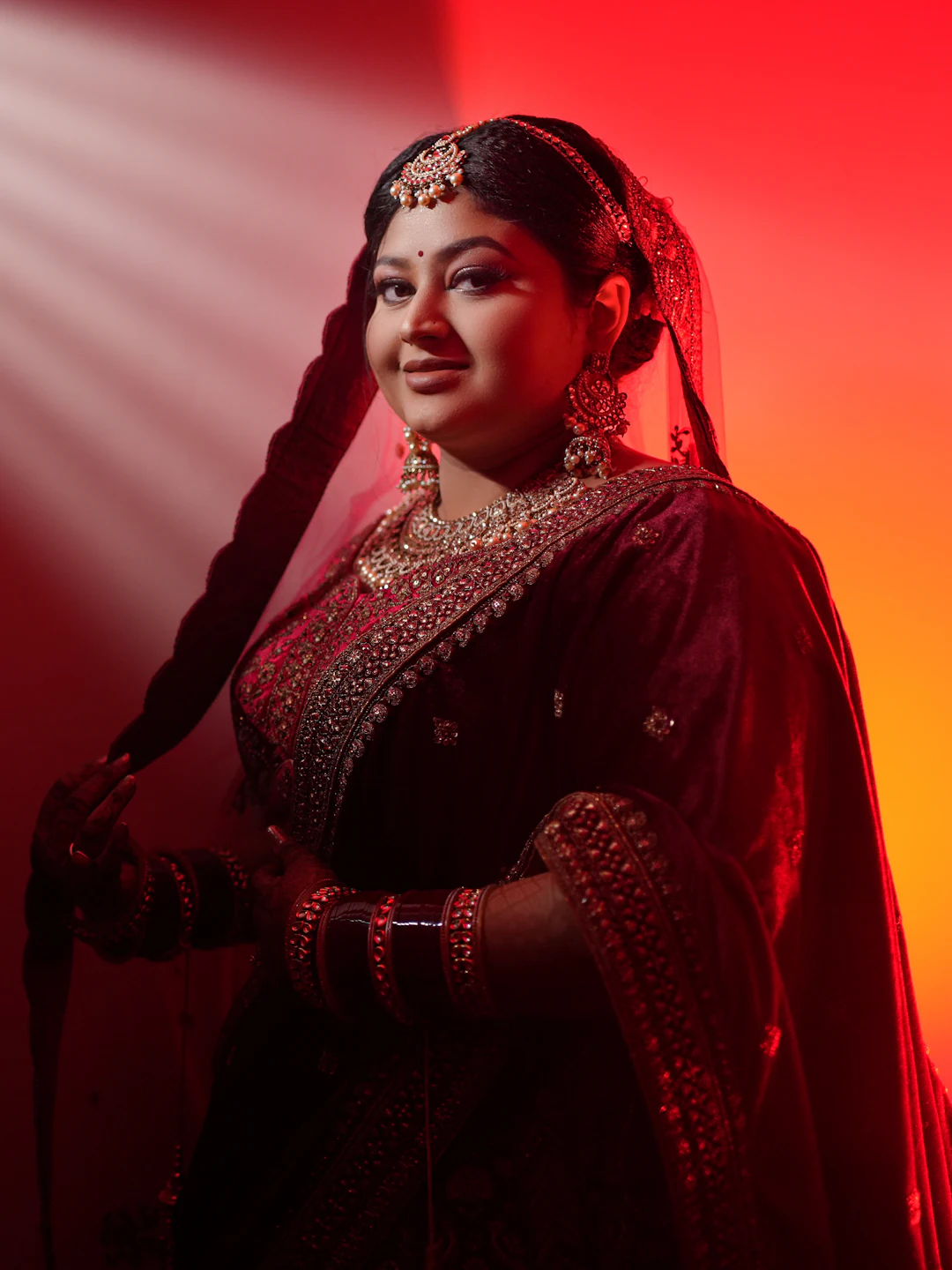 A singer in a traditional lehenga performing under warm stage lights